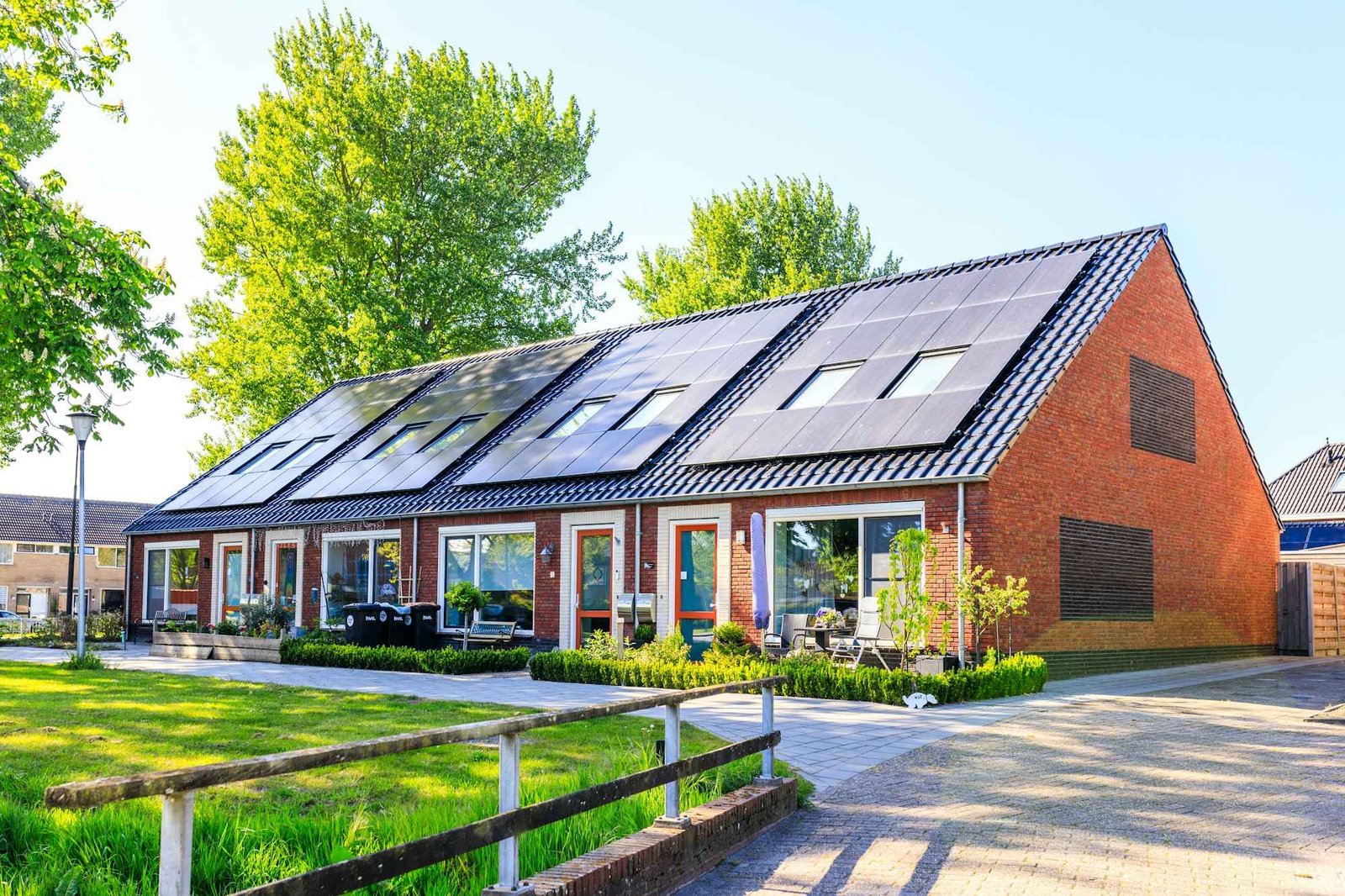 Maisons en brique rénovées avec panneaux solaires, jardin ensoleillé