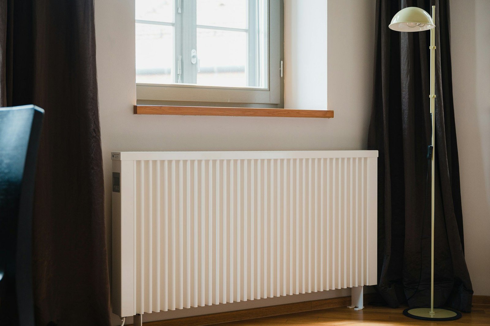 Radiateur blanc sous une fenêtre dans une pièce lumineuse